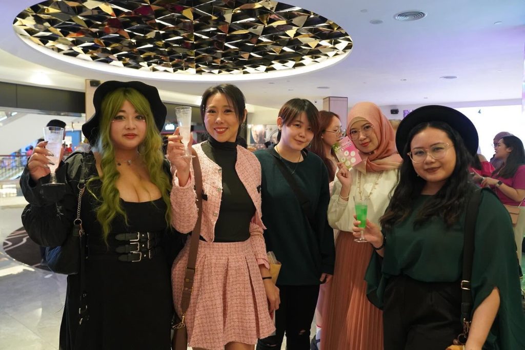Fans in pink and green outfits posing together during the Wicked celebration at TGV. | TGV Blog