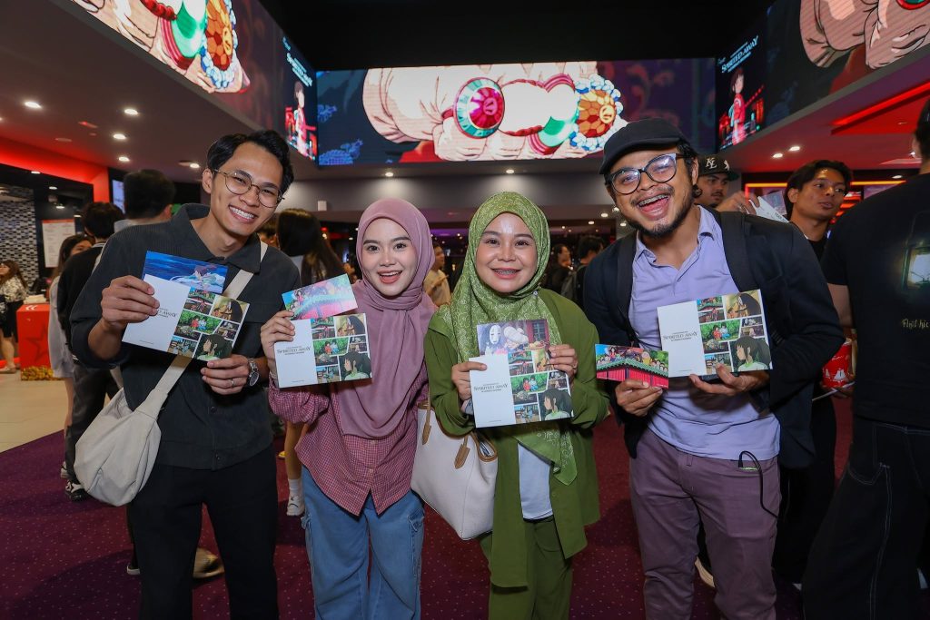 Group of fans smiling and holding Spirited Away event passes during the TGV Ghibli fan screening. | TGV Blog