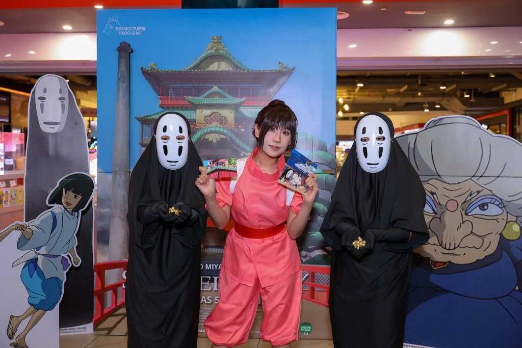 Fans posing with No-Face mascots and Spirited Away character standees at the TGV event photo area. | TGV Blog